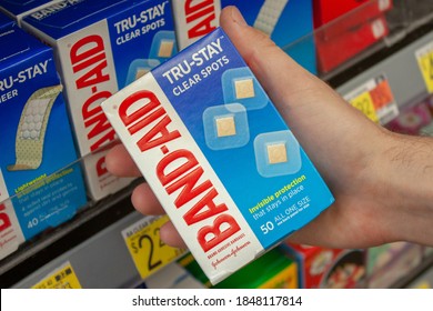 Albuquerque, New Mexico / USA - November 2 2020: Man Holding A Box Of Band-Aids In Walmart In The Pharmacy And Over-the-counter Medication Aisle