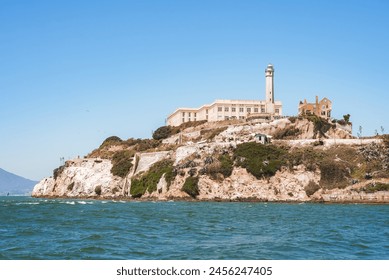 Alcatraz Island view from water in San Francisco Bay, California, USA. Rugged coastline, former prison, iconic lighthouse, clear sky, calm water, sparse vegetation, historical landmark. - Powered by Shutterstock