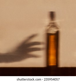 Alcohol Addiction Concept - Shadow Of Hand Reaching For Bottle Of Alcohol