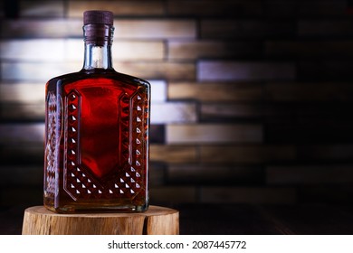 Alcohol bottle on wooden stand by brick wall