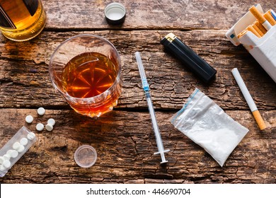 alcohol, cigarettes, drugs, pills on a wooden background