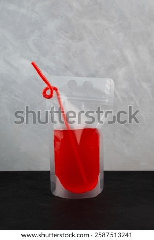 Alcohol cocktail or Adult drink in reusable pouch with drinking straw. Red wine or fruit beer in plastic bag very convenient for party and picnics. Take away drink.