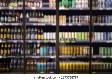 Alcohol And Cold Beverage In Cooler At Liquor Store. Bottles And Cans Of Alcohol Drinks For Sale.