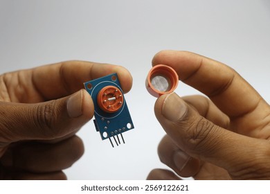 Alcohol detection sensor module with a view of its inside components held in the hand. Mq3 sensor disassembled