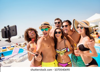 Alcohol glasses holiday leisure toothy mad people blue sky sea concept. Six excited cheerful attractive active joking friendly people taking self portrait against swimming pool with chaise-longues - Powered by Shutterstock