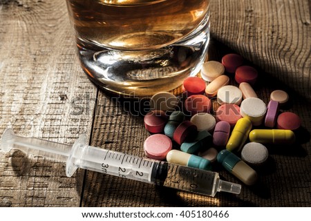 Alcohol and pills on table with shadow