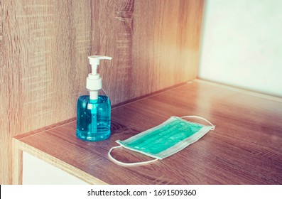 Alcohol sanitizer and medical mask on wooden table with copy space,Coronavirus,Covid-19 prevention.