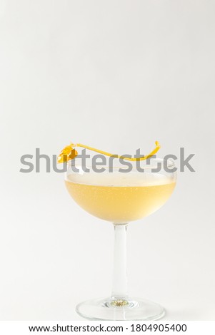 alcoholic beverage served in coupe glass in white background
