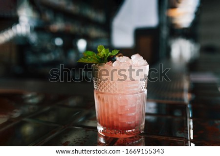 Alcoholic blueberry cocktail at bar background. Closeup.