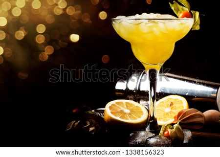 Alcoholic cocktail with beer, ice and lemon juice, bar tools. Low key, selective focus