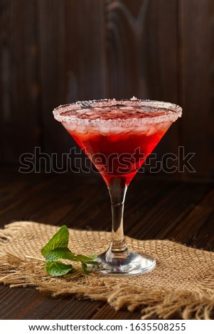 Alcoholic cocktail in a glass on a dark wooden background. 