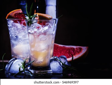 Alcoholic Cocktail With Grapefruit Juice, Crushed Ice, Vodka And Rosemary, Night Neon Light, Black Stone Background, Selective Focus