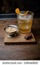 Alcoholic Cocktail With Peanuts And Candy On A Wooden Table