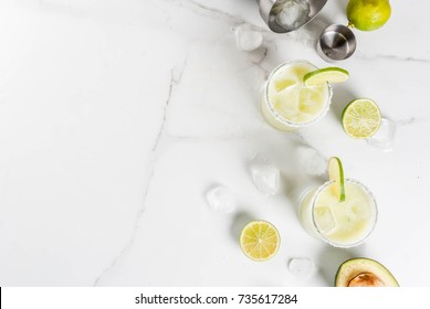 Alcoholic Cocktail Recipes And Ideas. Avocado And Lime Margarita With Salt, On A White Marble Kitchen Table. Copy Space Top View