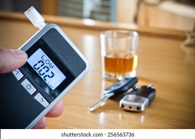 Alcoholic drink, breathalyzer and car keys - do not drink and drive concept - Shutterstock ID 256563736