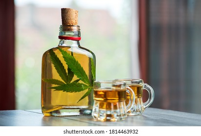 Alcoholic drink whiskey brandy or schnapps infused with marijuana with cannabis leaf in the bottle