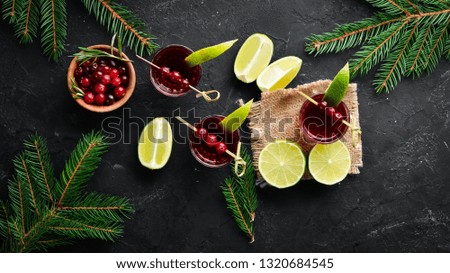 Alcoholic liqueur from a cranberry in a glass. Cranberry, lime, rosemary. On a rustic background. Top view. Free space for your text.
