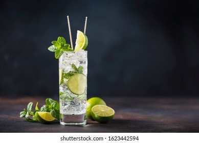 Alcoholic mojito with lime, mint  and ice on the black background, selective focus image