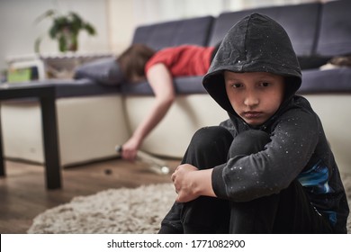 Alcoholic Mother Passed Out In An Unconscious State With A Bottle In Her Hands. The Child Is Closed From This Problem. The Boy, Unattended, In A Depressed State, Suffers.