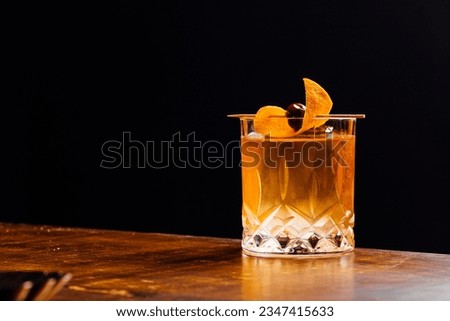 Alcoholic Old Fashioned Cocktail classic on the rocks garnish with orange peel and a cherry