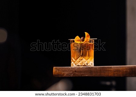 Alcoholic Old Fashioned Cocktail classic on the rocks garnish with orange peel and a cherry
