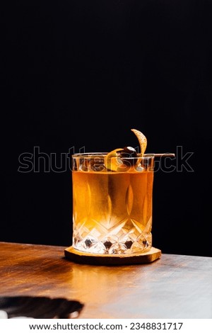 Alcoholic Old Fashioned Cocktail classic on the rocks garnish with orange peel and a cherry