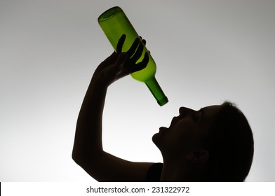 Alcoholic woman's silhouette with an empty wine bottle