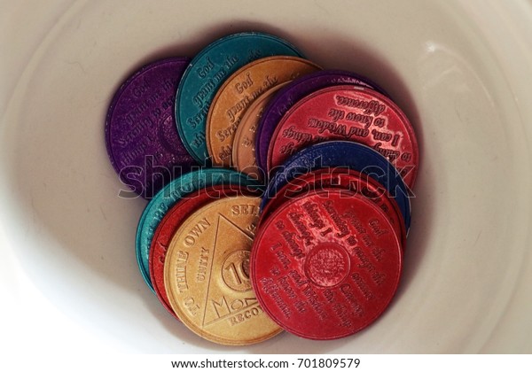 Alcoholics\
anonymous chips displayed in a white\
bowl