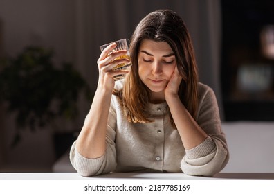 alcoholism, alcohol addiction and people concept - drunk woman or female alcoholic drinking whiskey at home