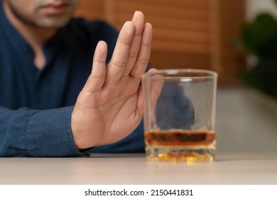 Alcoholism, Depressed Asian Young Man Refuse, Push Out Alcoholic Beverage Glass, Drink Whiskey, Sitting Alone At Night. Treatment Of Alcohol Addiction, Having Suffer Abuse Problem Alcoholism Concept.