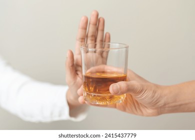 Alcoholism, hand of refuse alcoholic beverage, drink whiskey while person holding glass give to her. Treatment of alcohol addiction, having suffered abuse problem alcoholism isolated on background.