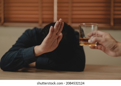 Alcoholism, Sad Depressed Asian Young Man Refuse, Push Alcoholic Beverage Glass, Drink Whiskey, Sitting Alone At Night. Treatment Of Alcohol Addiction, Having Suffer Abuse Problem Alcoholism Concept.