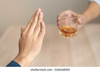 Alcoholism, Sad Depressed Asian Young Man Refuse, Push Alcoholic Beverage Glass, Drink Whiskey, Sitting Alone At Night. Treatment Of Alcohol Addiction, Having Suffer Abuse Problem Alcoholism Concept.