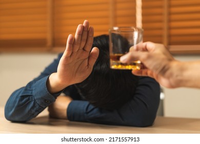 Alcoholism, Sad Depressed Asian Young Man Refuse, Push Alcoholic Beverage Glass, Drink Whiskey, Sitting Alone At Night. Treatment Of Alcohol Addiction, Having Suffer Abuse Problem Alcoholism Concept.