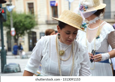 ALCOY, SPAIN - SEPTEMBER 21, 2019: Woman Wearing Skimmer Hat, Pearl Necklace And Vintage Cosmetic Earrings 19th And Early 20th Century  Attire At Alcoy's 3rd Annual Modernist Fair Cultural Event.