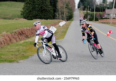 ALDERGROVE, BC/CANADA - MARCH 1, 2015: A Male And Female Cyclist Compete During The Escape Velocity Spring Series Cycling Race Near Aldergrove, British Columbia On March 1, 2015. 