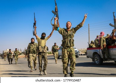 Aleppo, Syria 12 September 2017: Fighters from the armed Syrian opposition raise their badges of victory with their hands after the victory over ISIS