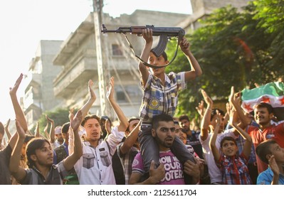Aleppo, Syria-February 15, 2012: People protesting the war, boy holding a symbolic weapon.Civil war continues in Syria. Aleppo, the country's second largest city, was heavily damaged in the war.