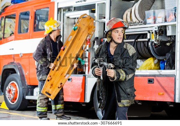 Alert Male Firefighter Holding Hose While Stock Photo (Edit Now) 307666691