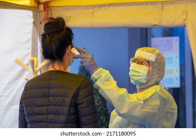 Alert Omicron 5, Pandemic Covid-19. Triage Hospital Field Tent For The First AID, A Mobile Medical Unit For Patient Infected With Corona Virus. Doctor With Protective Mask Checks The Patient's Fever.	