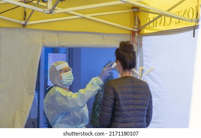 Alert Omicron 5, Pandemic Covid-19. Triage Hospital Field Tent For The First AID, A Mobile Medical Unit For Patient Infected With Corona Virus. Doctor With Protective Mask Checks The Patient's Fever.	