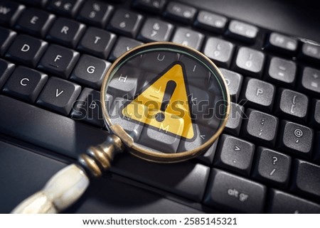 Alert warning exclamation mark notification on computer keyboard with magnifying glass for network security, malware or  virus threat and privacy error