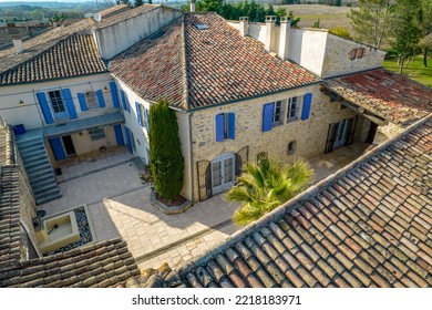 Ales, France - March 24th 2022 :aerial View With Drone Of A Courtyard Of A Property In The South Of France With A Villa With Stone Walls, Beautiful Blue Shutters, A Cypress And A Palm Tree, Tiles Roof