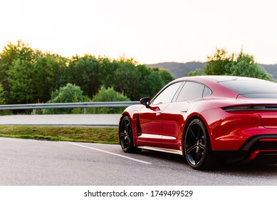 Alesund / Norway - May 31, 2020: Red Porsche Taycan sedan in a parking lot, parked for promotional purposes. Rear detail shot.