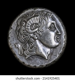 Alexander the Great head on Ancient Greek coin of Lysimachus, 290 BC. Silver tetradrachm, old rare money isolated on black, macro. Concept of Hellenistic Greece, valuable coin and ancient history.
