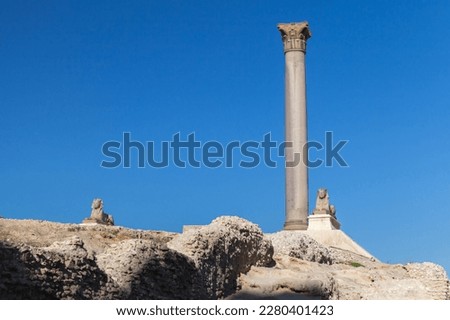 Alexandria, Egypt. Ancient stone sphinxes are near the Pompeys Pillar. This Roman triumphal column was built in 297 AD