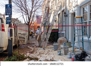 Alexandria, VA, USA 11-28-2020: A Local Construction Crew Is Working On A Home Improvement Project Including Exterior Painting. Ladders Are Set And A Sheet Covers The Sidewalk To Avoid Paint Droplets.