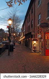 ALEXANDRIA, VIRGINIA - DECEMBER 7 2017: Businesses along King Street, one of the main thoroughfares running towards the Potomac River in Old Town Alexandria, with holiday decorations at night.