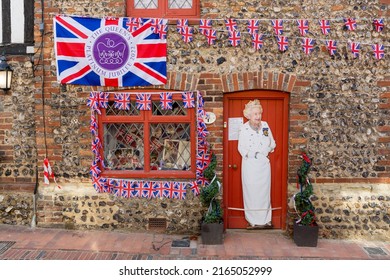 Alfriston, East Sussex, United Kingdom - June 3rd 2022: Life size cut out of Queen Elizabeth II along with a Union Jack flag and bunting displayed on a traditional cottage as part of the jubilee
