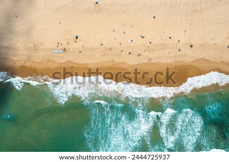 Luftaufnahme von fliegenden Drohnen von Menschen, die sich am Algarve Beach in Portugal entspannen.